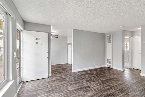 A room with wood flooring and a ceiling fan.