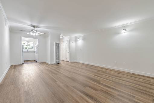 A room with a ceiling fan and a window.