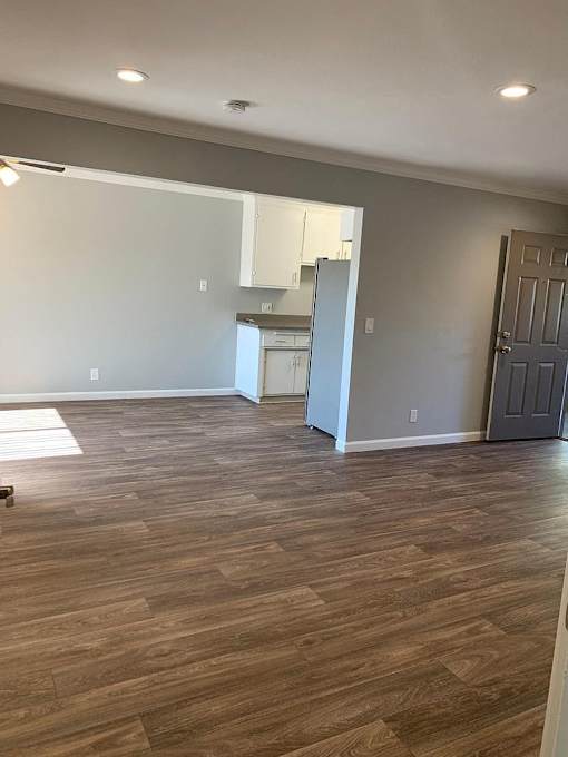 A kitchen area with a refrigerator and a door.