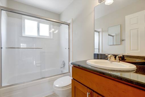 A bathroom with a toilet, sink, and shower.