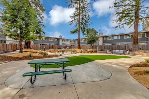 our apartments have a community picnic area with a green picnic table