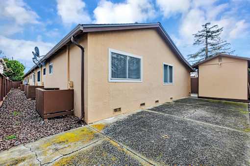 A beige house with a brown satellite dish on the roof.