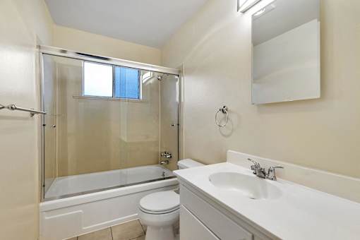 A white bathroom with a toilet, sink, and bathtub.
