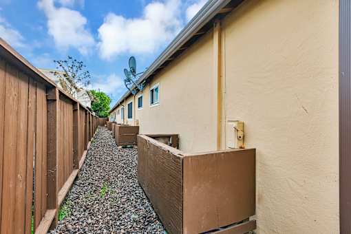 A long, narrow building with a brown fence on the left side.