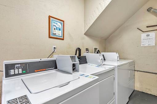 A row of white washing machines in a laundromat.