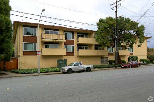 an apartment building with a white truck parked in front of it