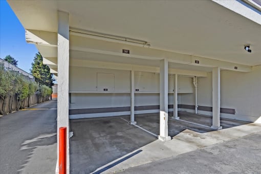 A parking garage with a white ceiling and concrete floor.