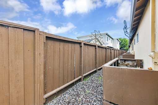 A wooden fence runs along the side of a house.