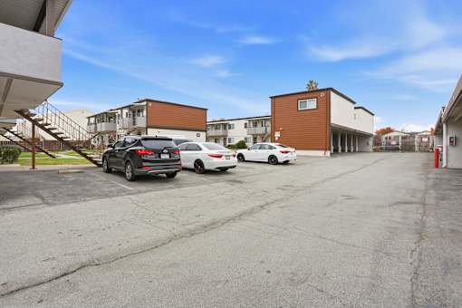 A parking lot with cars and buildings in the background.