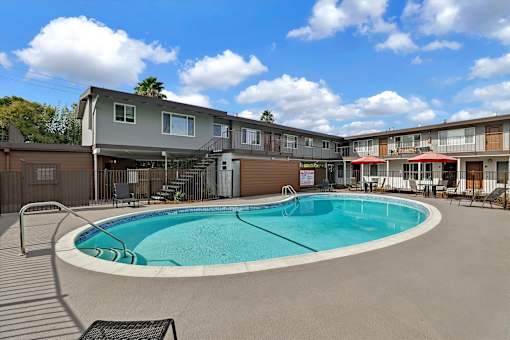 A swimming pool in a courtyard surrounded by buildings.