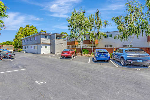 A parking lot with cars and a building in the background.