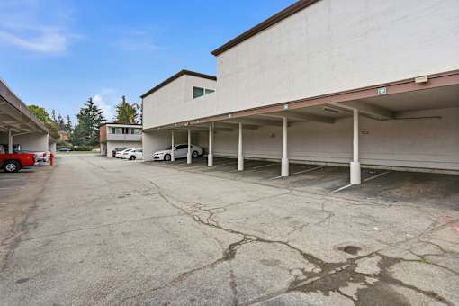 A parking lot with a white car and a red car.