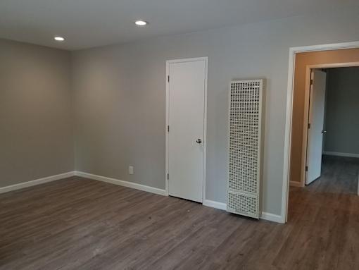 A room with a white door and a white panel on the wall.