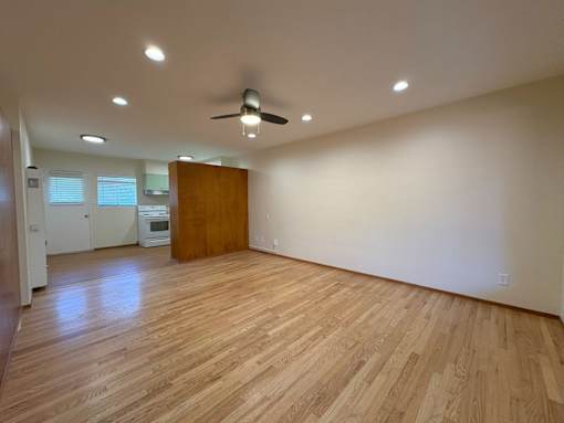 A room with wooden flooring and a ceiling fan.