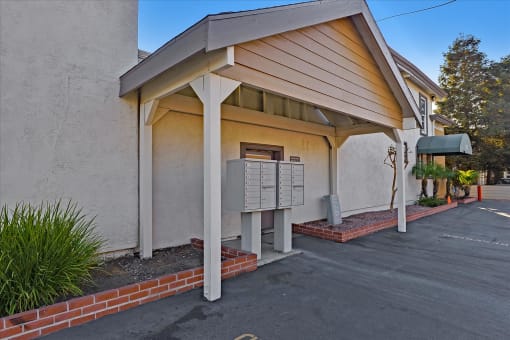 A building with a covered parking area in front.