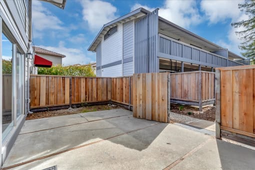 the back yard of a unit with a wooden fence and a gate