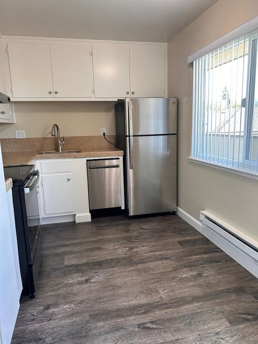 a kitchen with a stainless steel refrigerator and a window