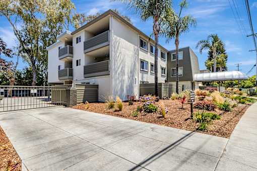 A modern apartment building with a driveway in front.
