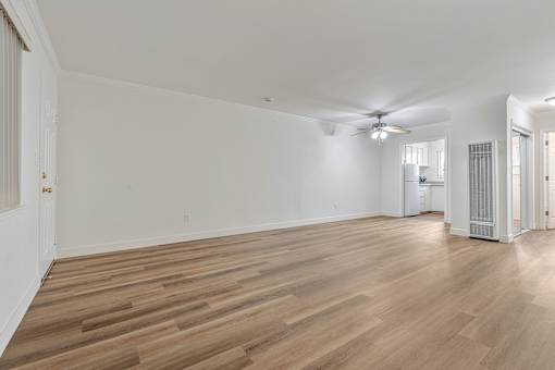 A room with wooden flooring and a ceiling fan.