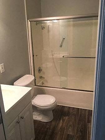 A white toilet sits in a bathroom next to a walk-in shower.