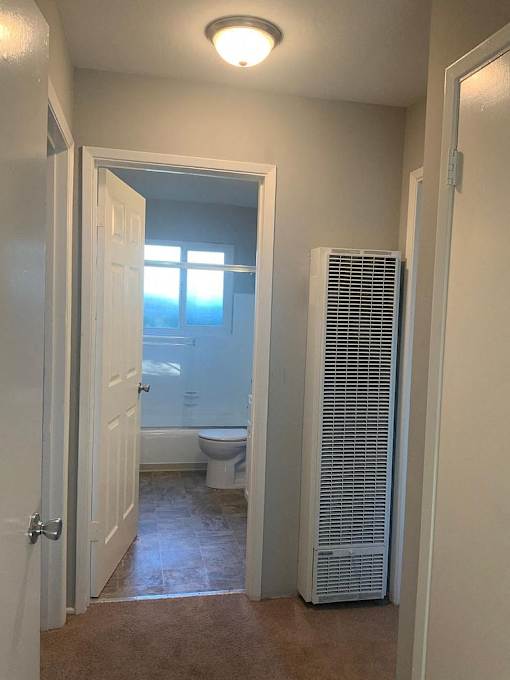 A bathroom with a toilet, sink, and window.