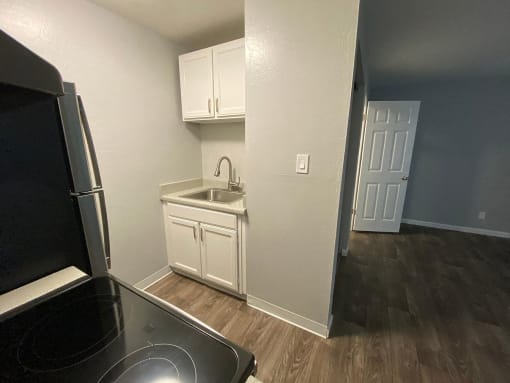 a kitchen with white cabinets and a black stove and refrigerator
