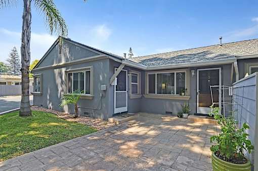 A house with a grey exterior and a tiled patio.