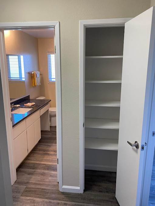 A white door is open to a room with a kitchen counter and cabinets.