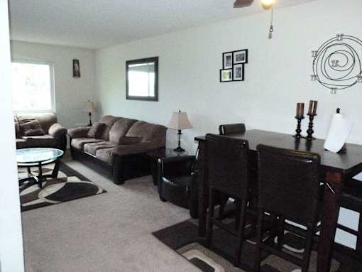 A living room with a couch, chairs, and a table.