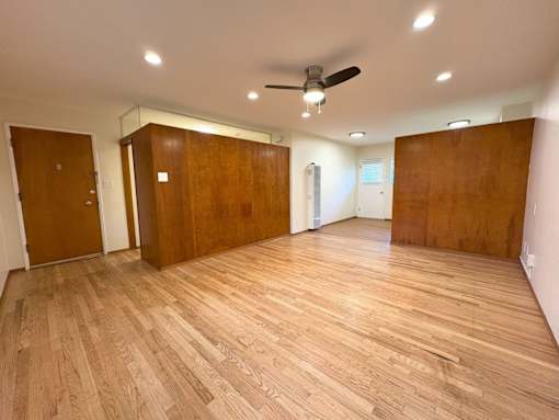 A room with wooden floors and a ceiling fan.