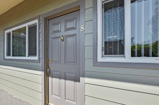 A grey door with a number 8 on it is on a house.