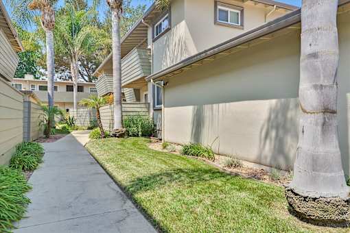 A row of houses with a concrete pathway in between.
