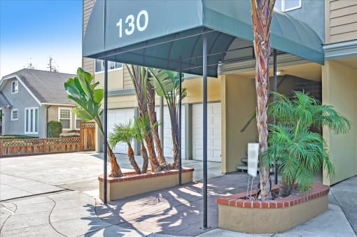 a building with a entrance with palm trees in front of it