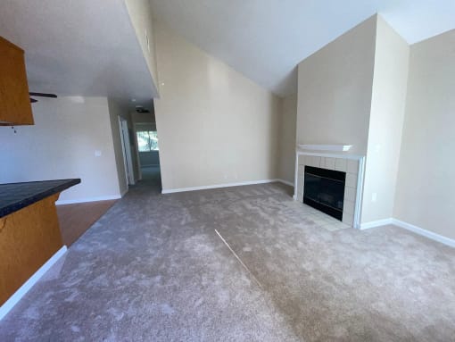 the living room of an empty house with a fireplace