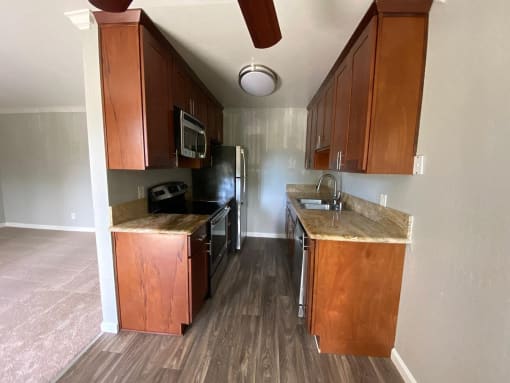 a kitchen with wooden cabinets and a stove and a sink