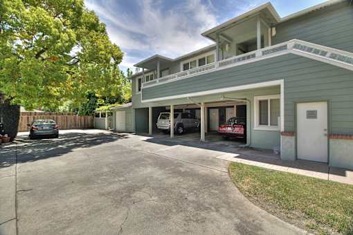 A two-story house with a garage and a tree in front.