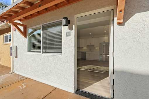 A modern house with a glass door leading to the kitchen.