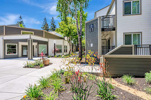 A modern building with a landscaped front yard.