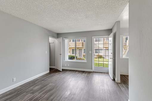 A room with a grey wall and a wooden floor.