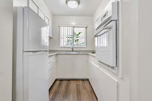 A white kitchen with a window and a sink.