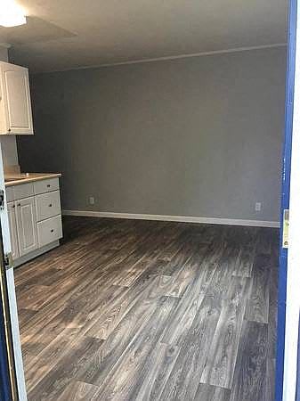 A kitchen with a white refrigerator and cabinets.