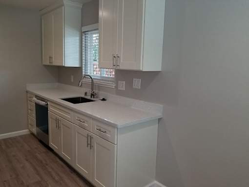 A kitchen with white cabinets and a white countertop.