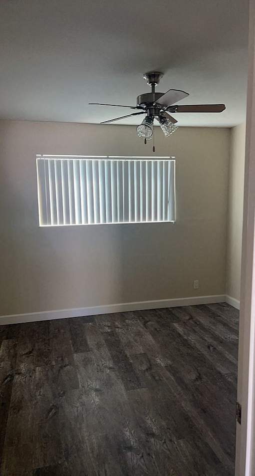 a empty room with a ceiling fan and a window
