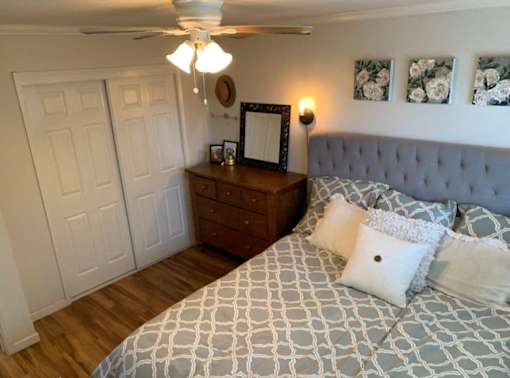 a bedroom with a bed and a dresser and a ceiling fan