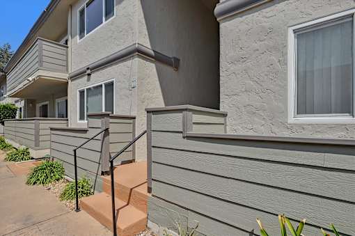 A concrete staircase with a metal railing leads up to a balcony.