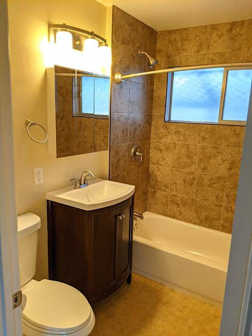 A bathroom with a toilet, sink, and bathtub.