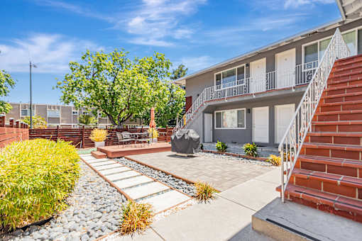 A sunny day at a residential area with a house and a tree.