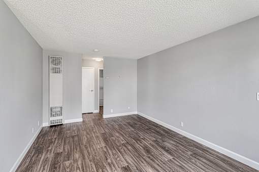 A room with wooden flooring and white walls.