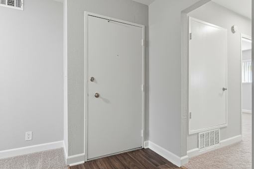 A white door is in a room with a carpet.
