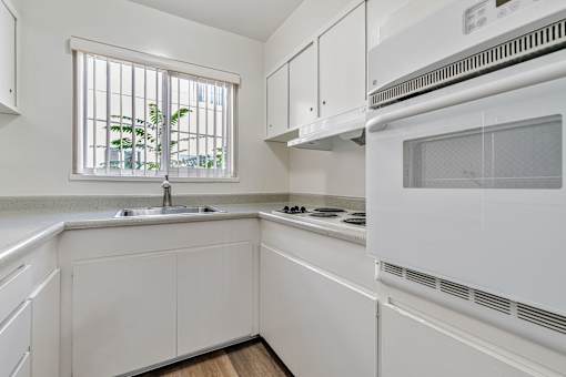A white kitchen with a window and a sink.